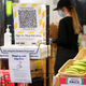 A New Zealand Covid Tracer App QR code and hand sanitizer sit at the entrance to a supermarket during the first day of a national lockdown on August 18, 2021 in Wellington, New Zealand.